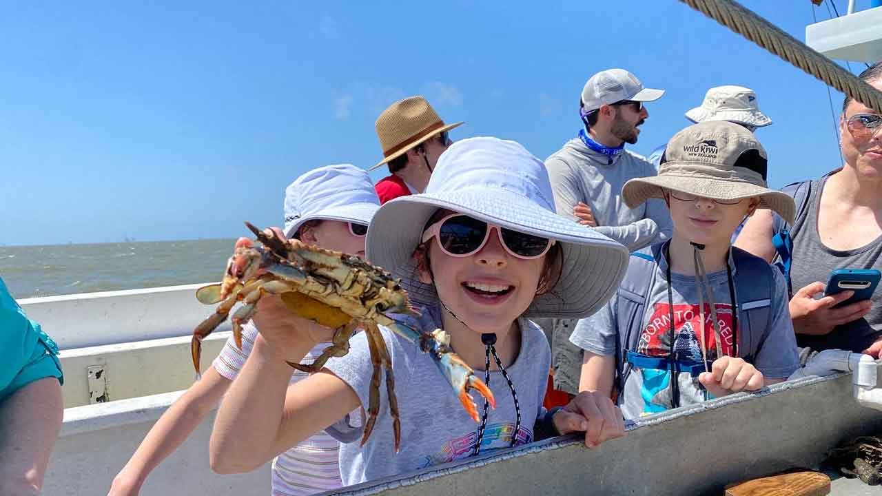 Girl holds crab on boat