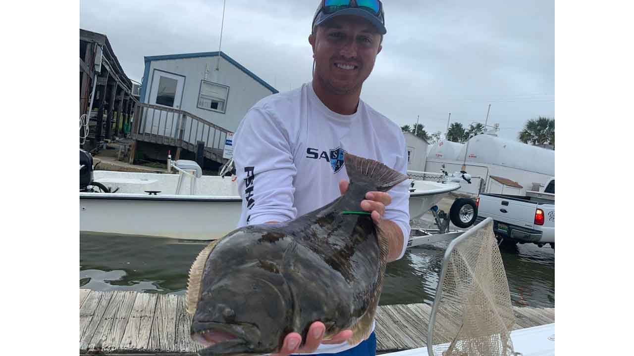 Dylan Kiene holds flounder with tag